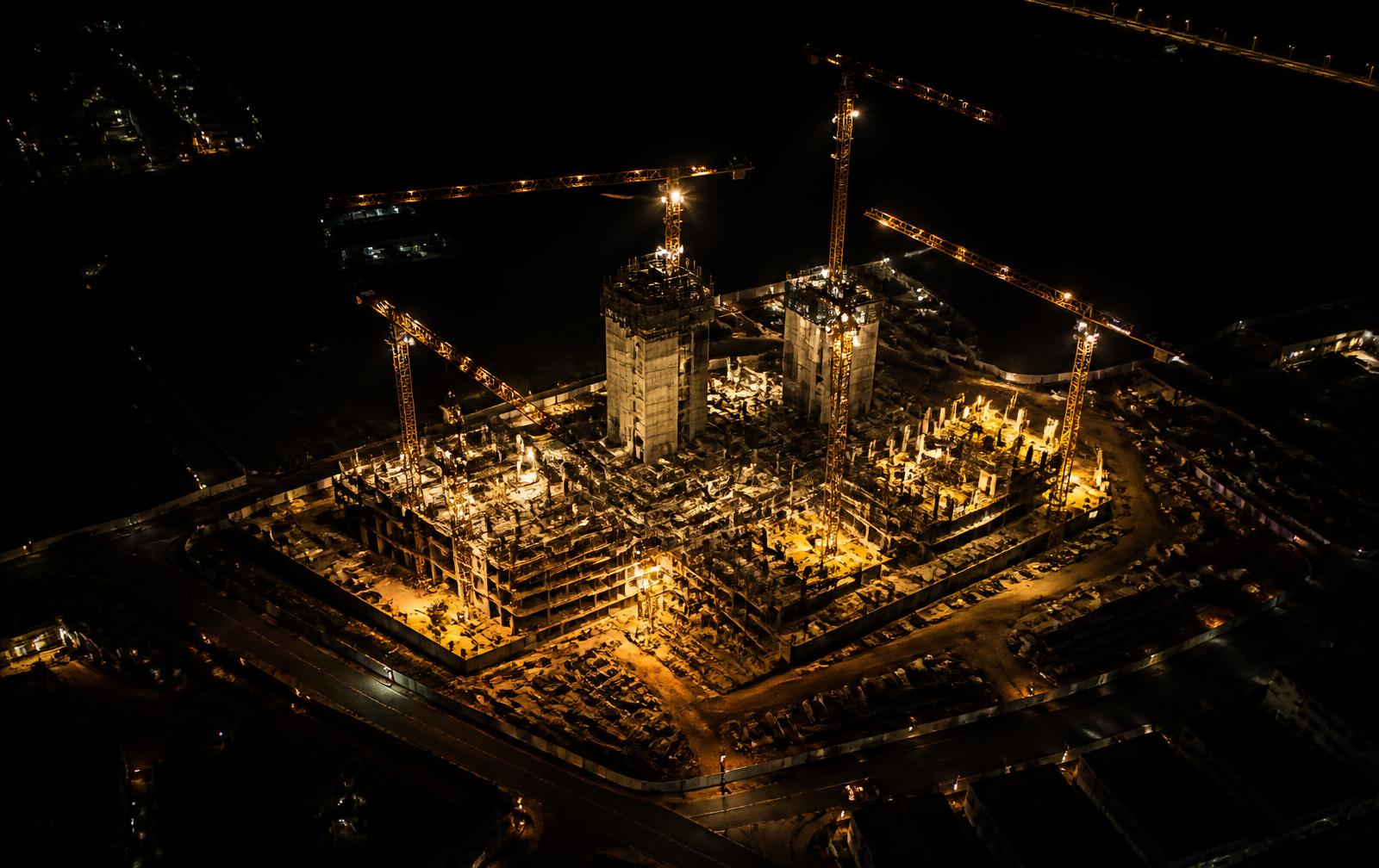 Aerial view of an illuminated construction development at night